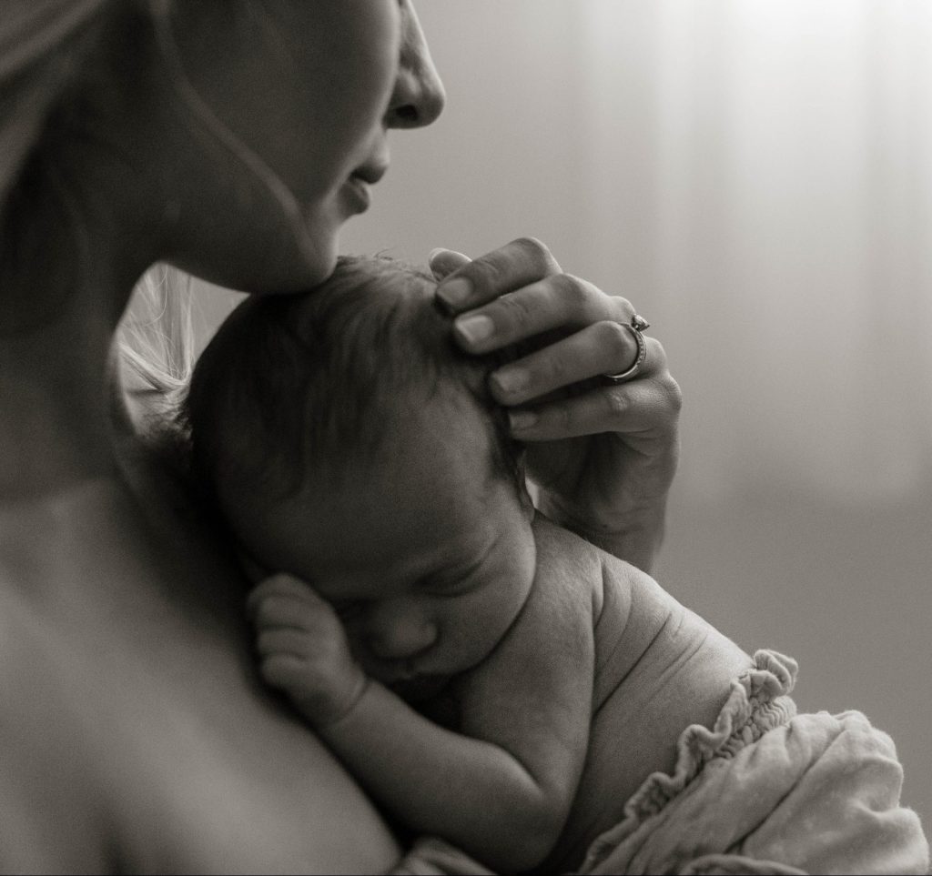 mom holding her baby during an in-home newborn session in West Michigan