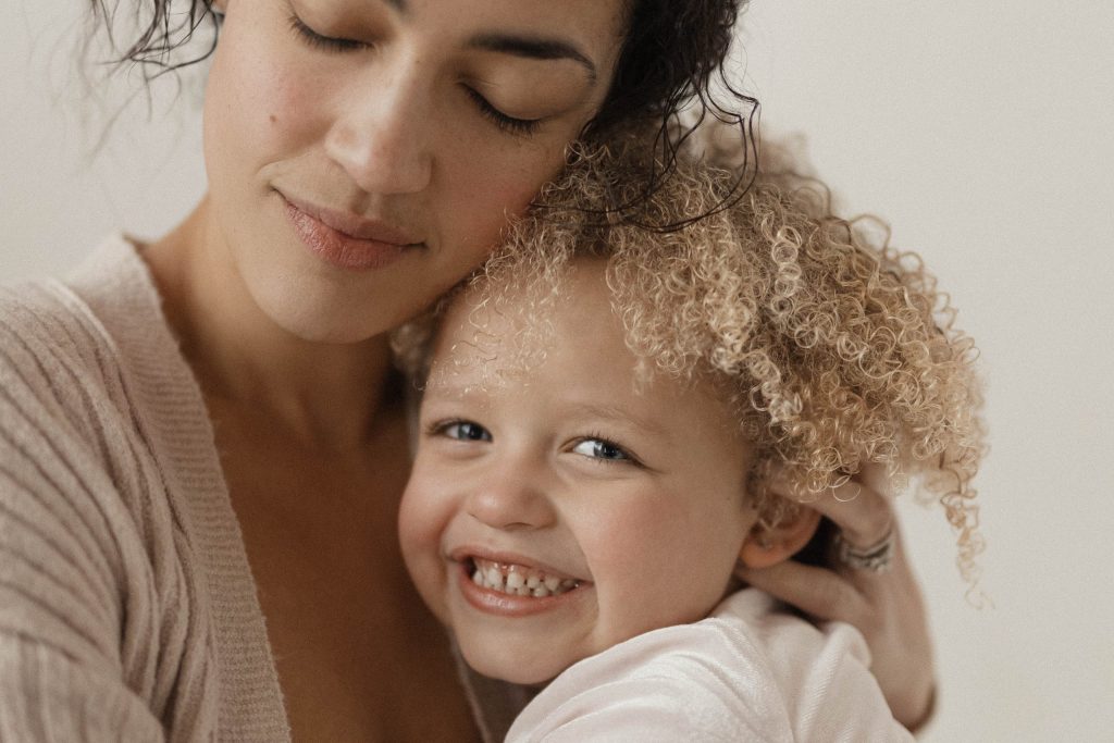 Mom hugging her daughter during natural light photoshoot in michigan