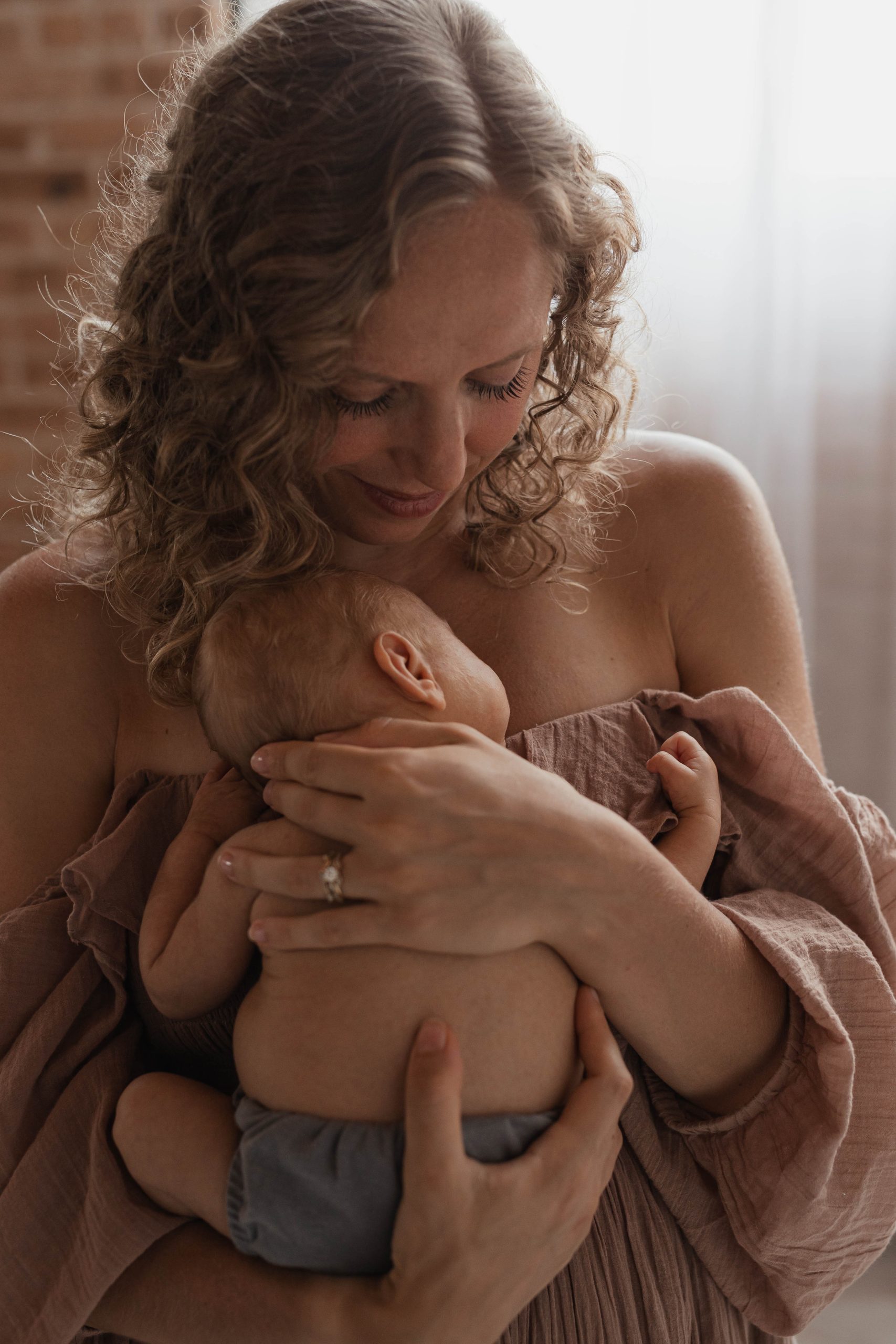 Natural intimate picture of newborn in mom's arms during a newborn session