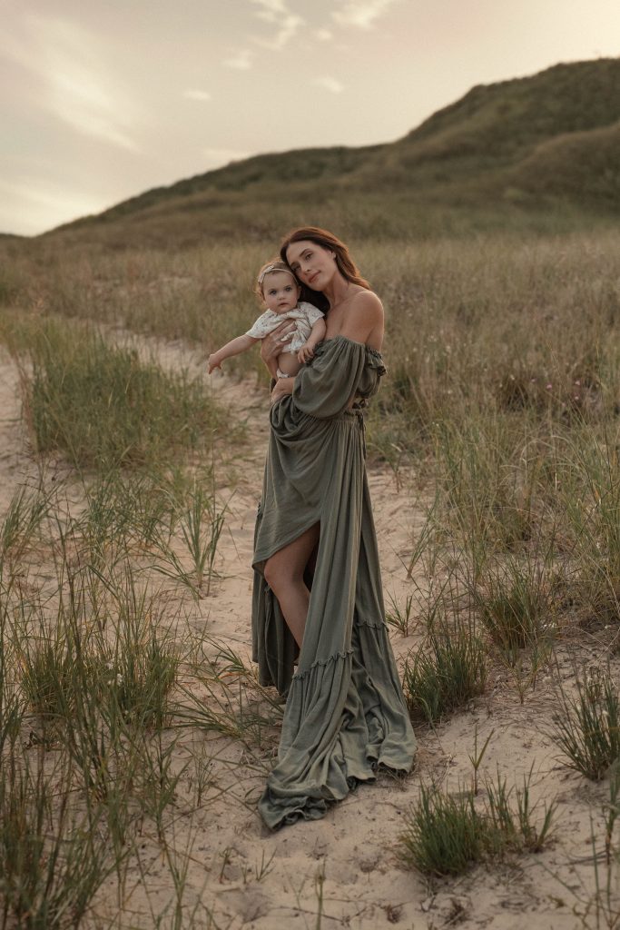moody picture of mom holding her 1 year old during a motherhood shoot in West Michigan