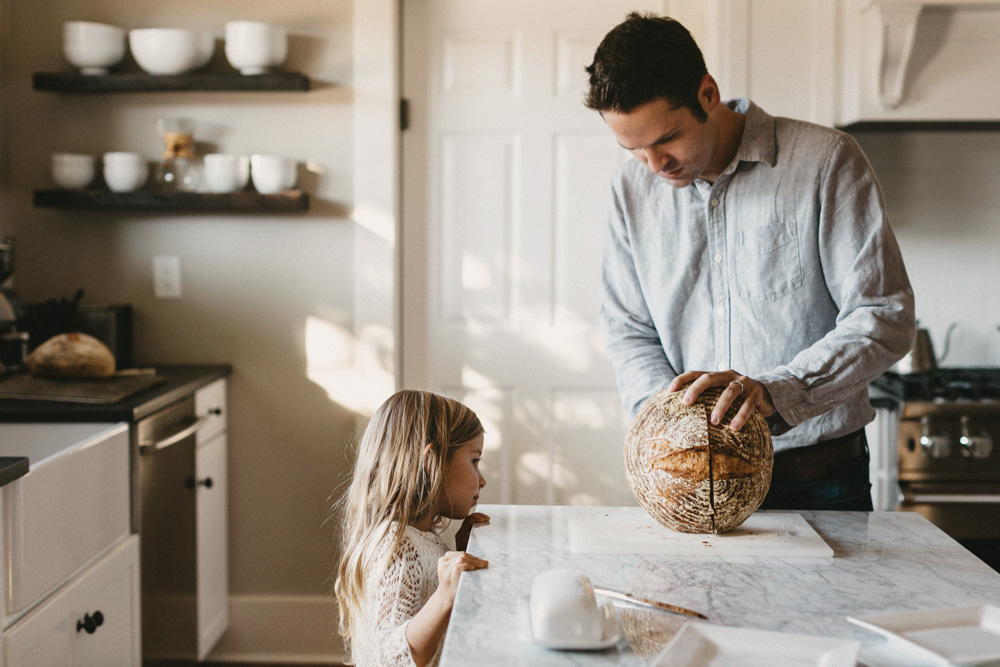 Dad and daughter cutting fresh bread during in-home photo session