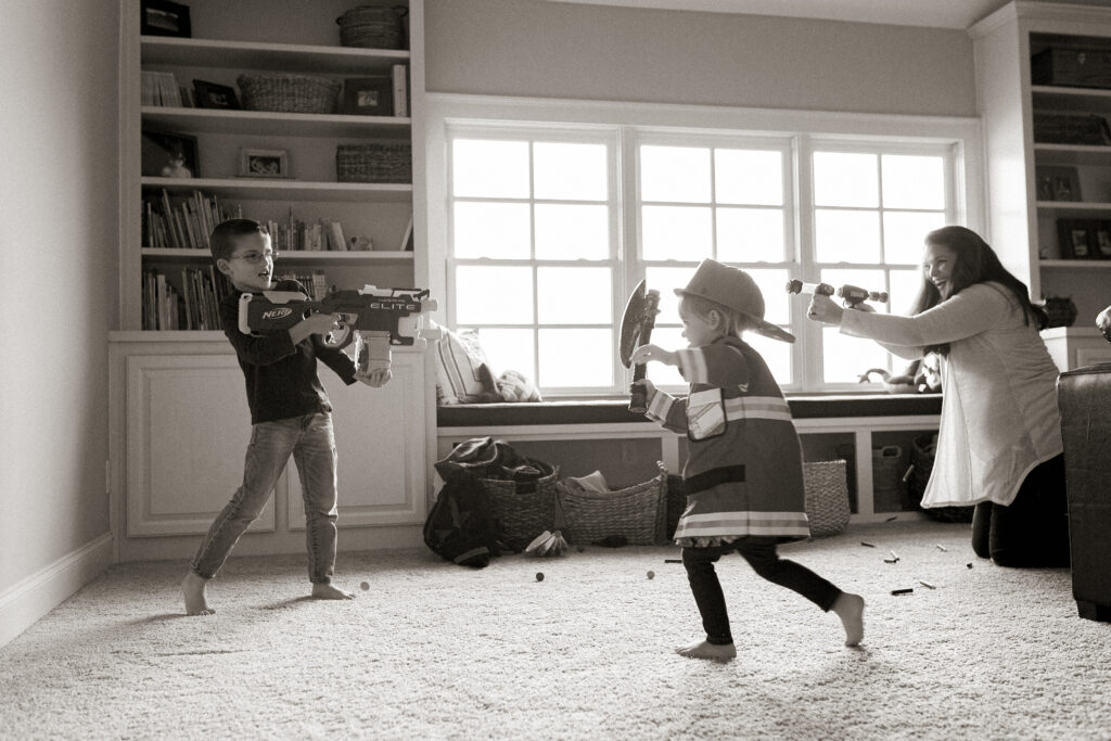 mom and kids playing nerf war during lifestyle in-home photo session with Alissa Saylor