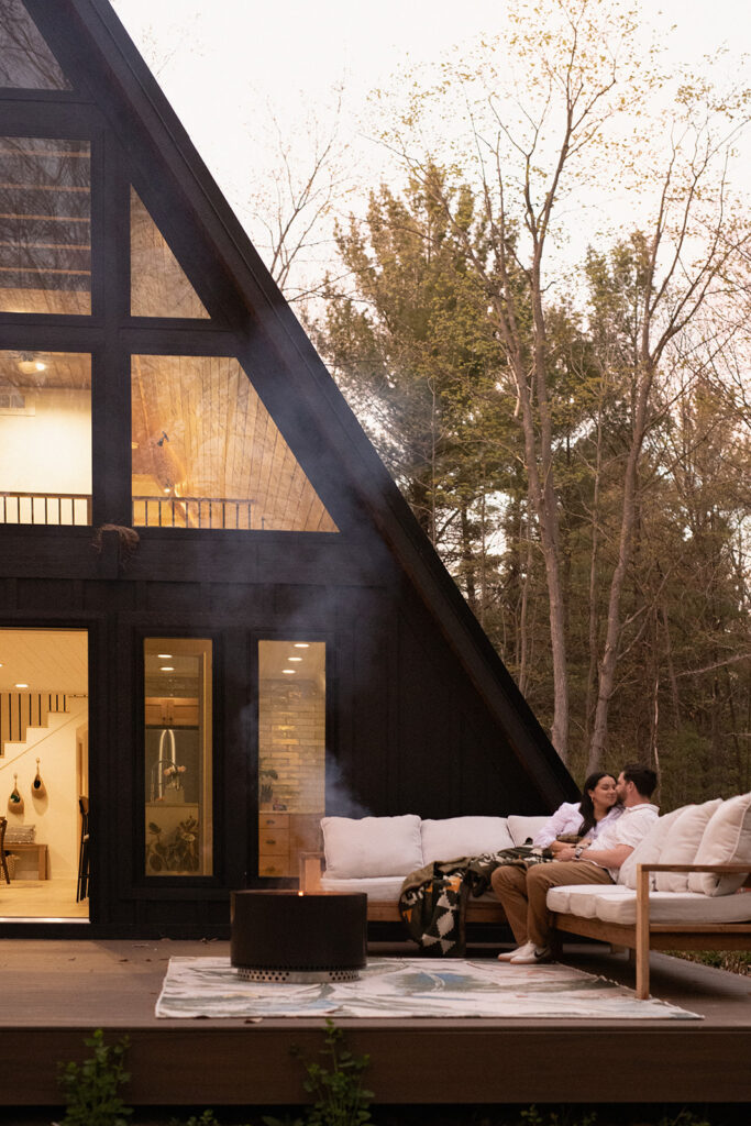 Family snuggling by a bonfire during an in-home photo session with Alissa Saylor